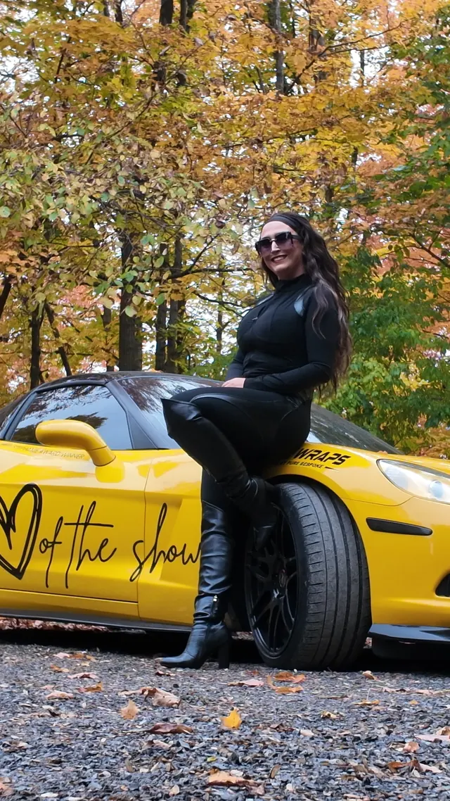Chelsea seated on the Corvette's front wheel arch.